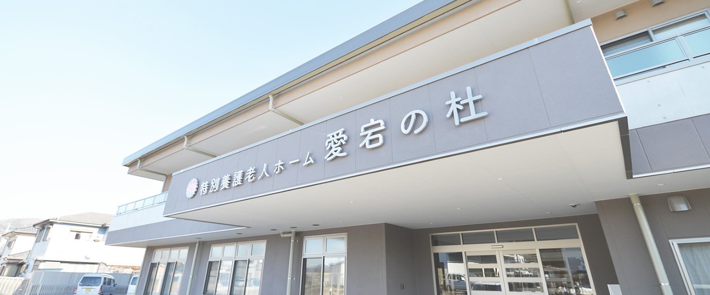介護老健ホーム「愛石の杜」の建物外観。施設名が大きく表示された看板が特徴。